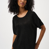 Woman wearing a black textured top against a white background