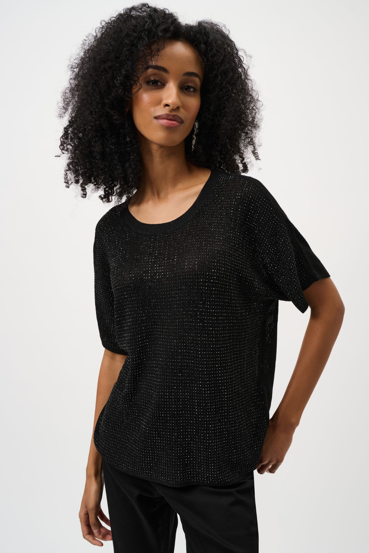 Woman wearing a black textured top against a white background