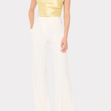 Woman wearing a yellow top and white pants on a white background