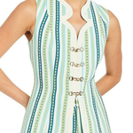 Woman wearing a sleeveless, striped top with decorative buttons on a white background