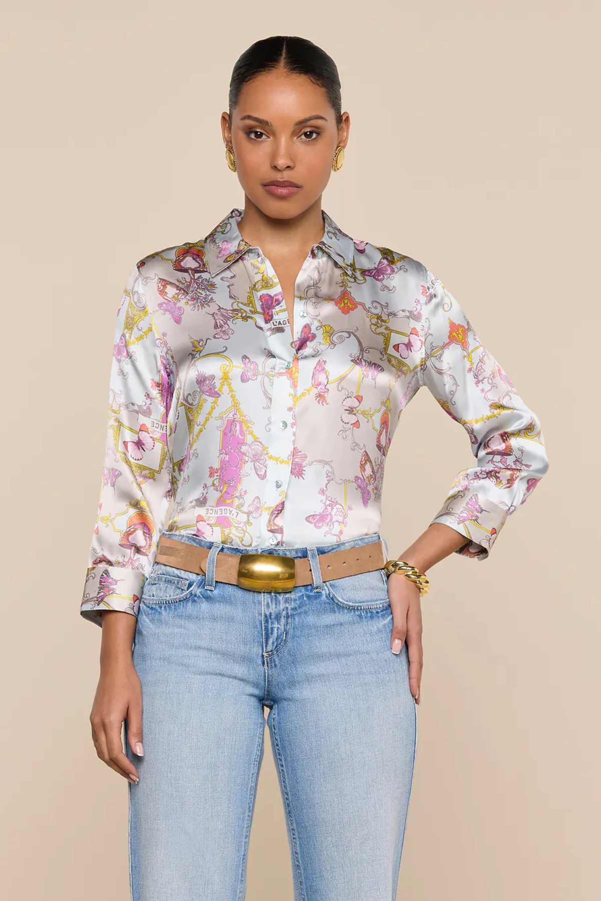 Woman wearing a floral blouse and jeans on a beige background