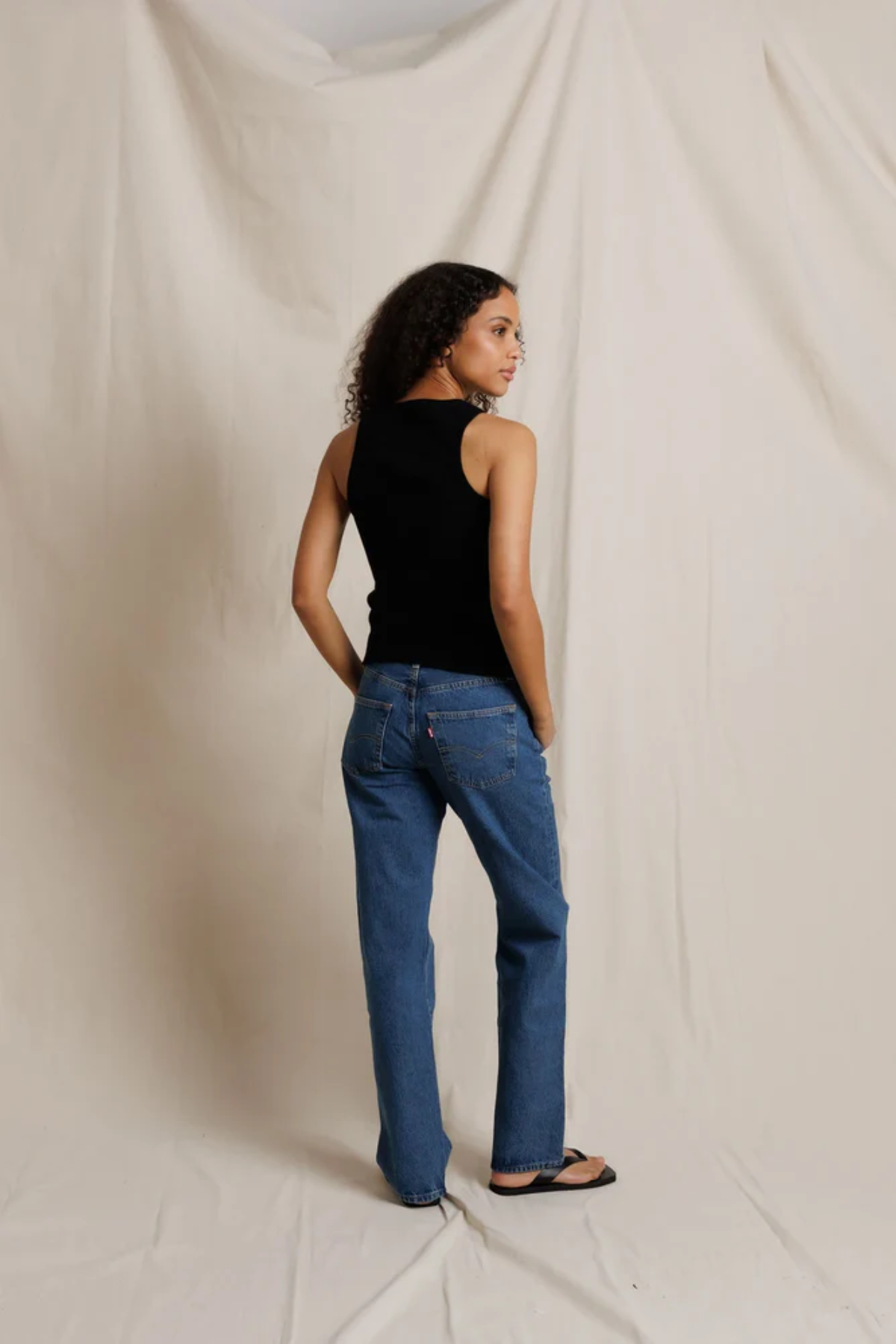 back of woman in black tank top and denim 