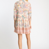 Woman wearing a patterned dress on a white background