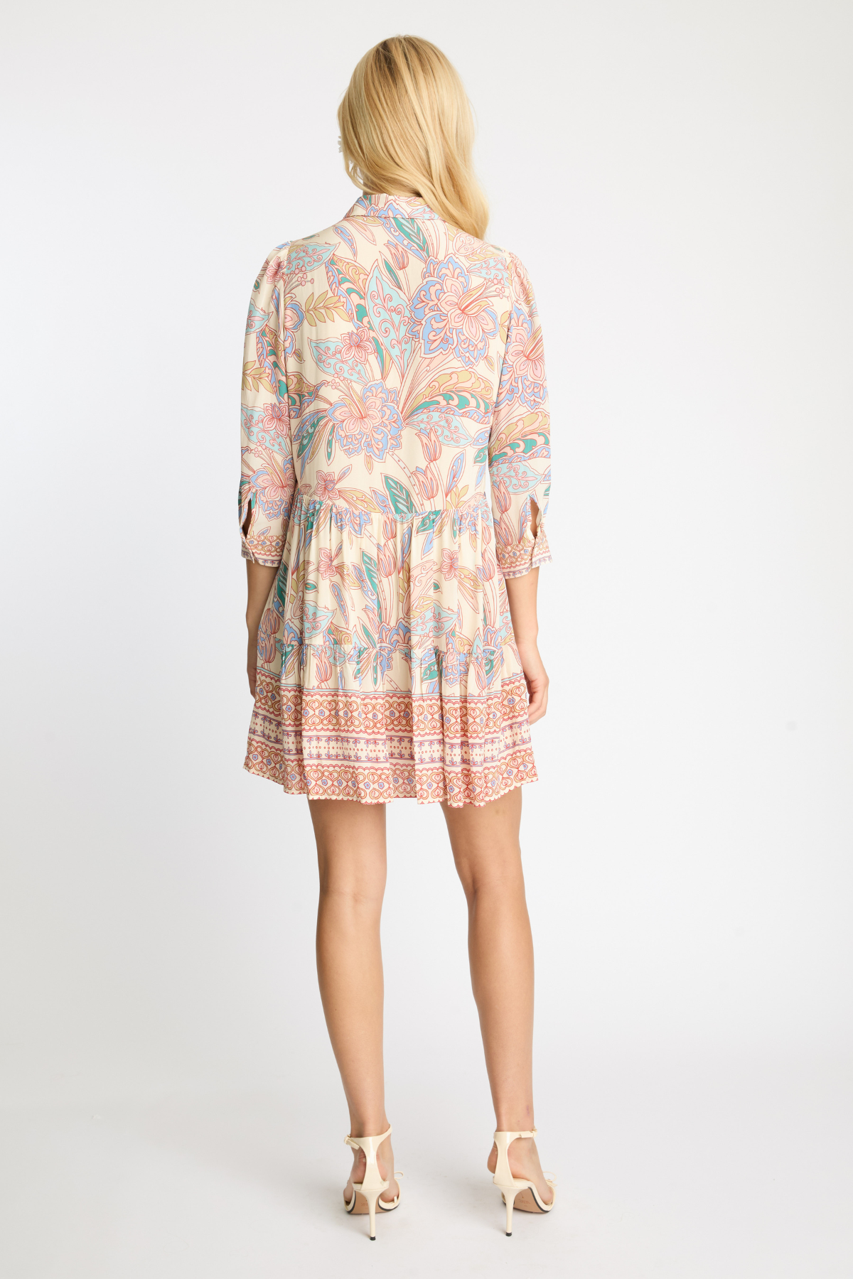 Woman wearing a patterned dress on a white background