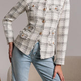 Person wearing a patterned blazer and light blue jeans against a neutral background