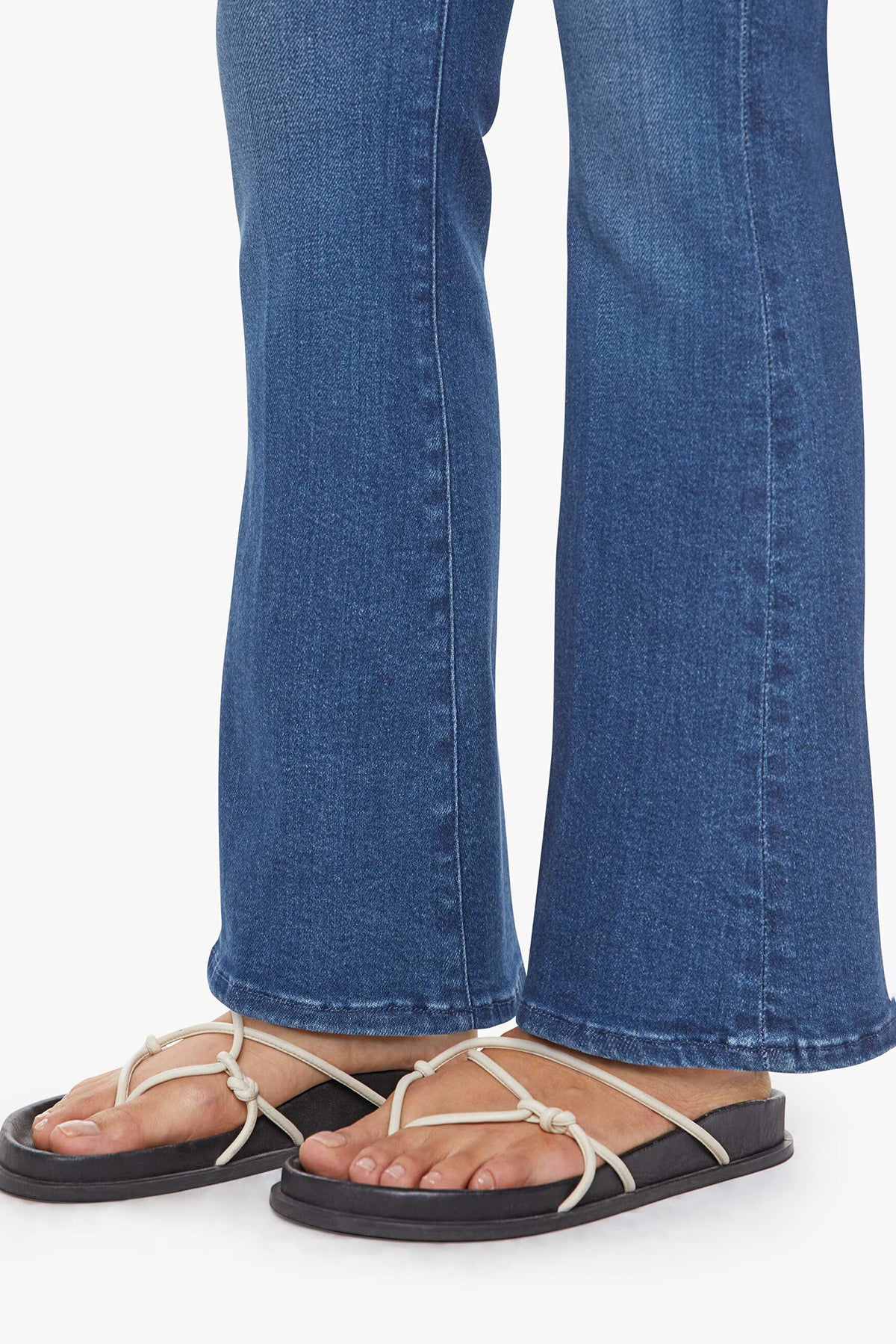 Woman wearing mid-wash flared jeans with a slim fit through the hip and gentle flare at the hem.