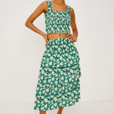 Woman wearing a green floral two-piece outfit on a white background