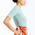 Woman wearing a soft mint cable knit sweater with a smooth, lightweight knit and polished neckline