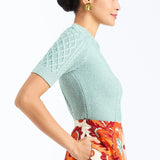 Woman wearing a soft mint cable knit sweater with a smooth, lightweight knit and polished neckline