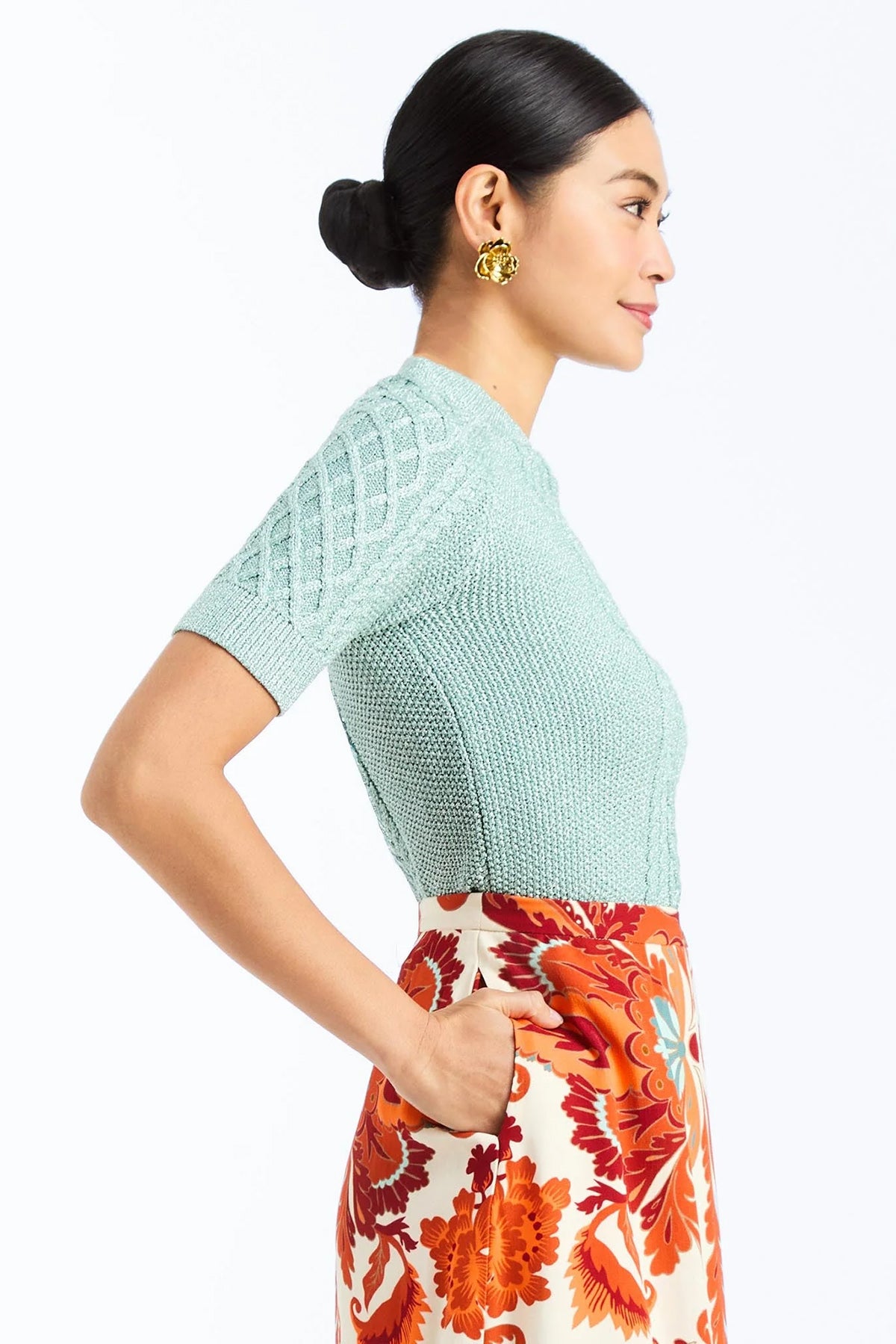 Woman wearing a soft mint cable knit sweater with a smooth, lightweight knit and polished neckline