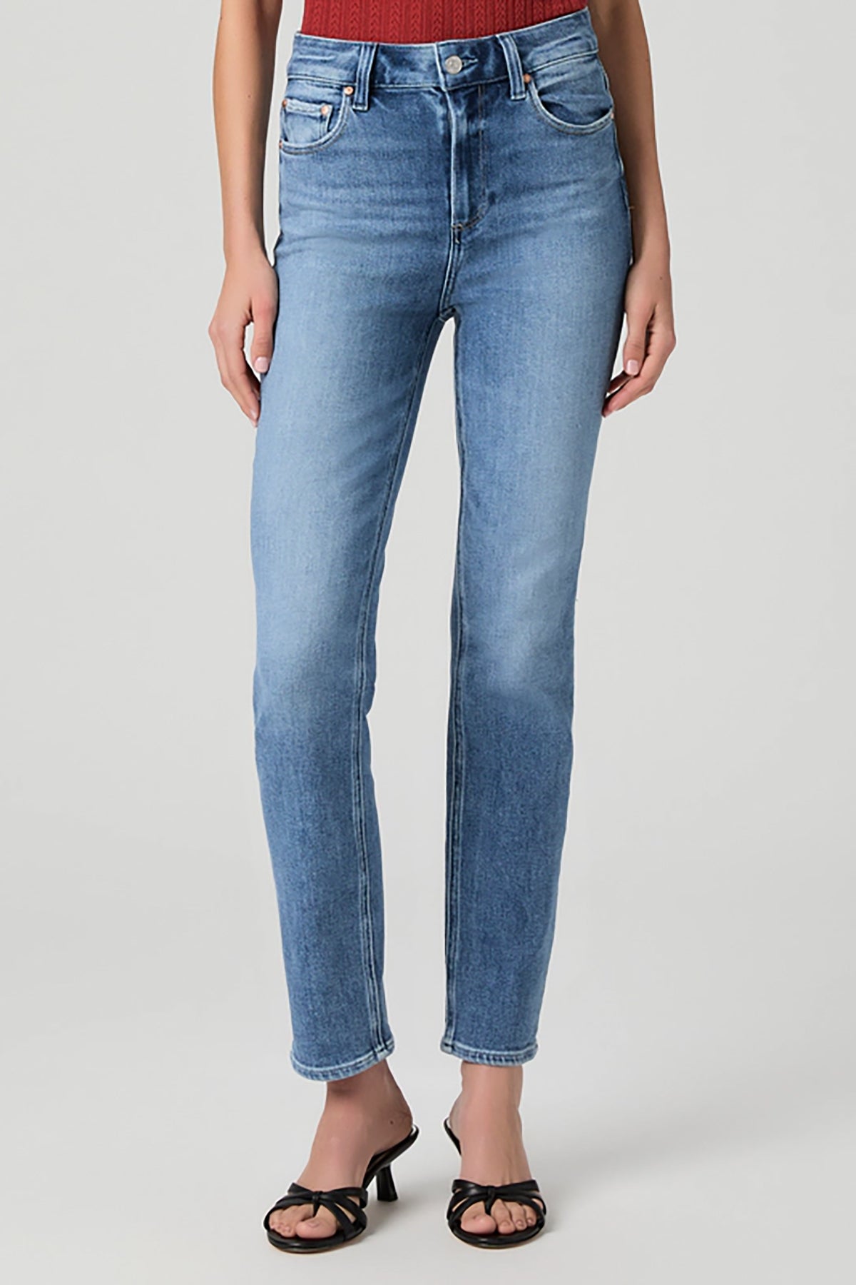Woman wearing mid-wash straight-leg jeans with a streamlined, classic silhouette.