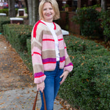Striped knit cardigan worn open over a simple top