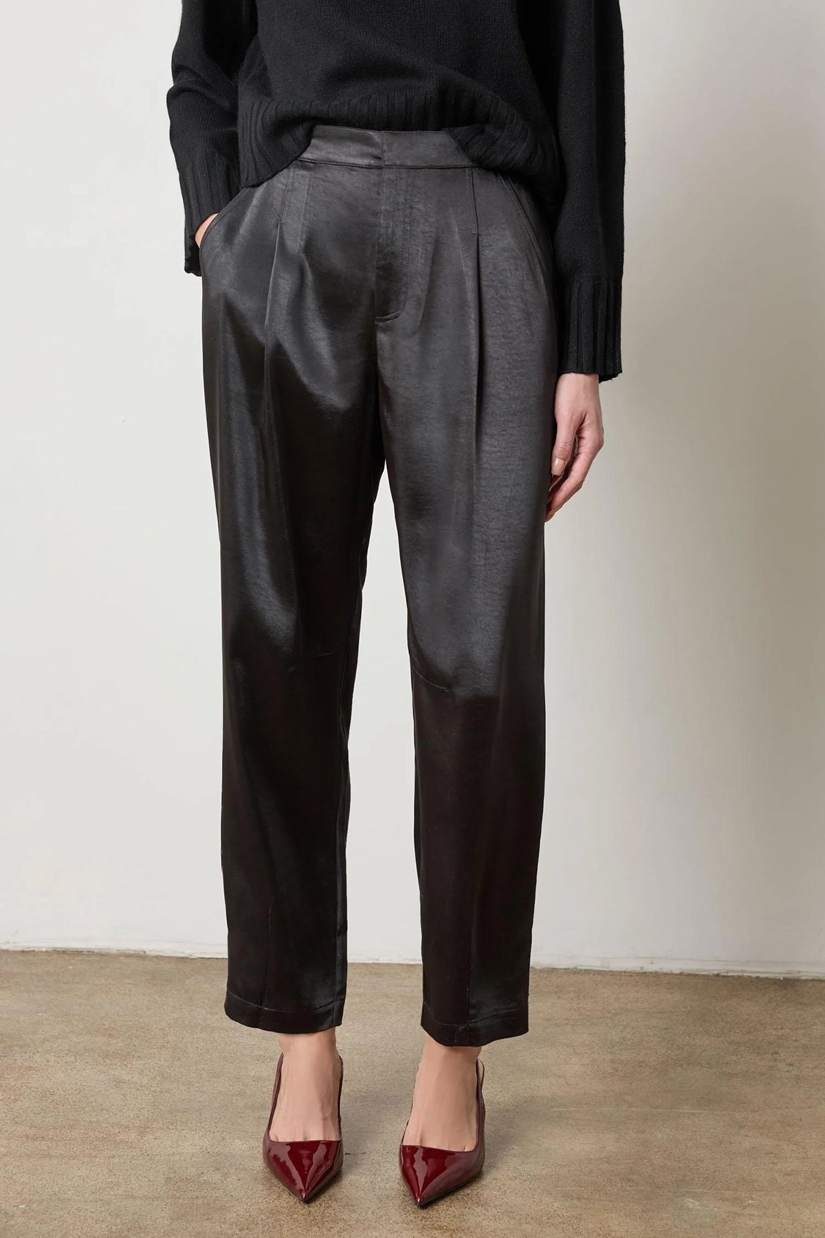 Black satin straight-leg pant with fly-front closure, styled with heels