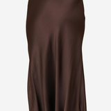 A dark brown satin midi skirt shown from the back on a model, featuring a smooth, flowing drape and a subtle sheen.
