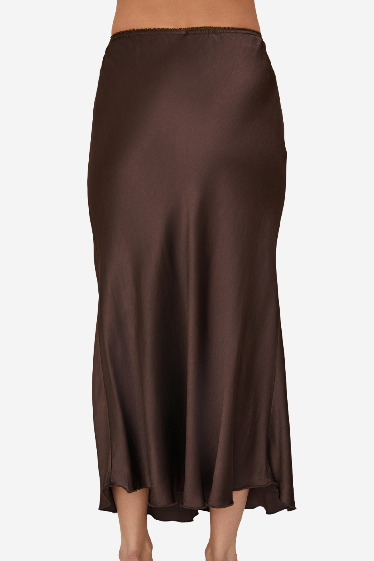A dark brown satin midi skirt shown from the back on a model, featuring a smooth, flowing drape and a subtle sheen.