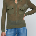 Model wearing a green knit button front sweater top with jeans on an off white background.