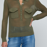 Model wearing a green knit button front sweater top with jeans on an off white background.