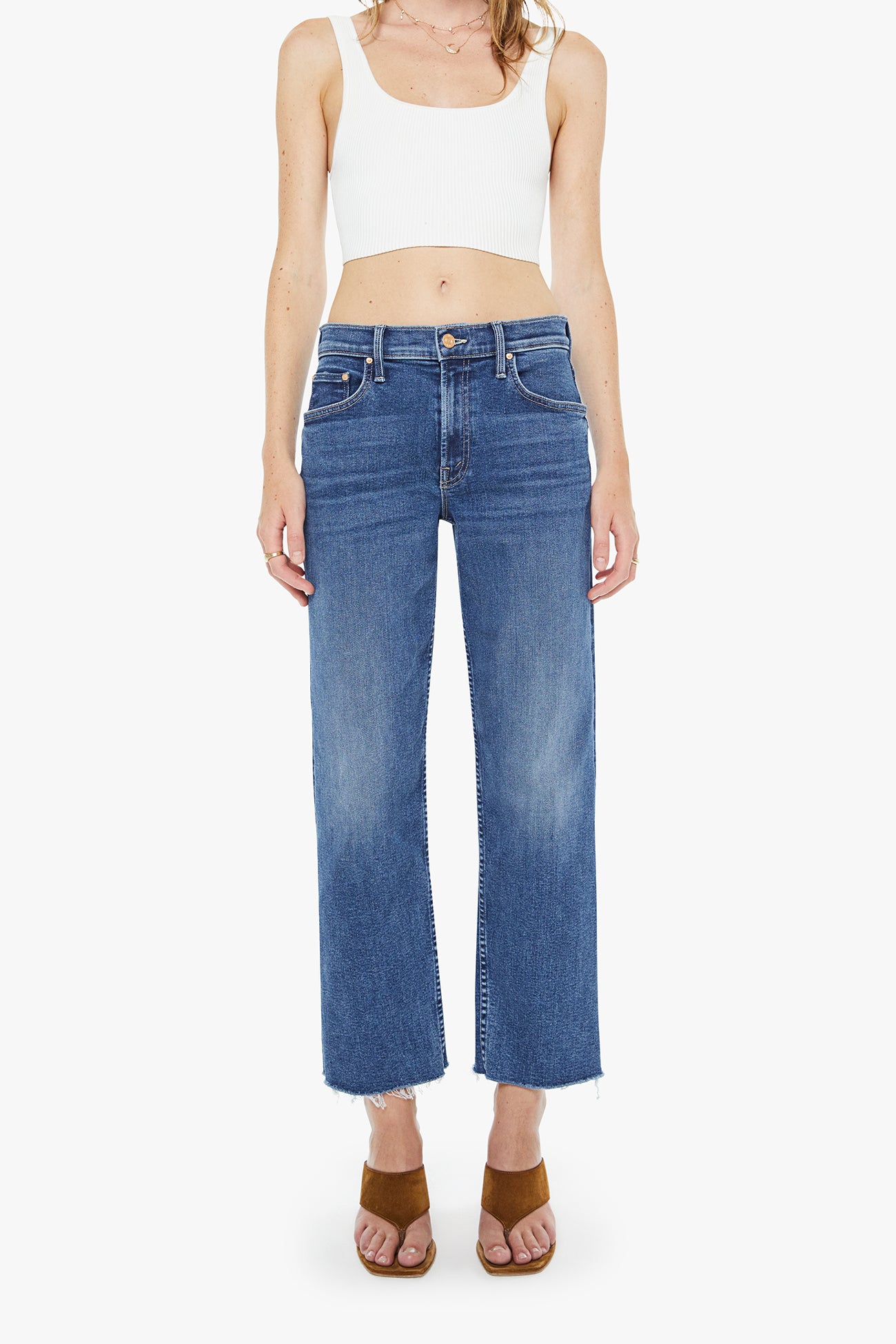 Person wearing blue jeans and a white tank top on a white background