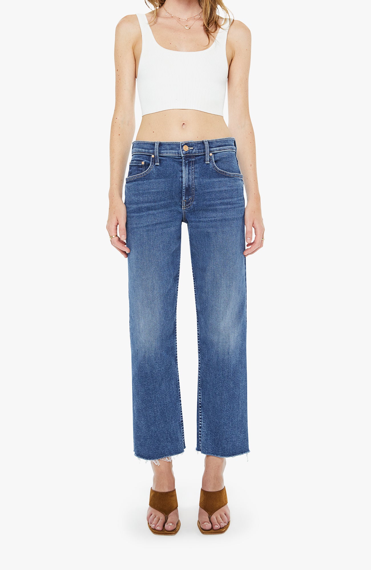 Person wearing blue jeans and a white tank top on a white background