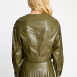 Person wearing an olive green leather jacket with lace sleeves on a white background