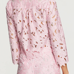 Pink floral dress worn by a person on a white background