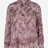 A long-sleeve button-up shirt with a zebra print pattern in burgundy and white, shown against a plain light gray background.