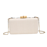 White clutch bag with gold chain and bamboo handle on a white background