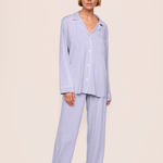 woman in purple pajama set on tan background 