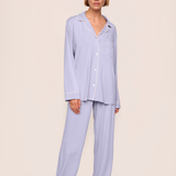 woman in purple pajama set on tan background 