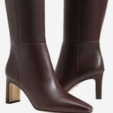 A pair of dark brown leather knee-high boots with pointed toes and block heels, shown against a plain light gray background.