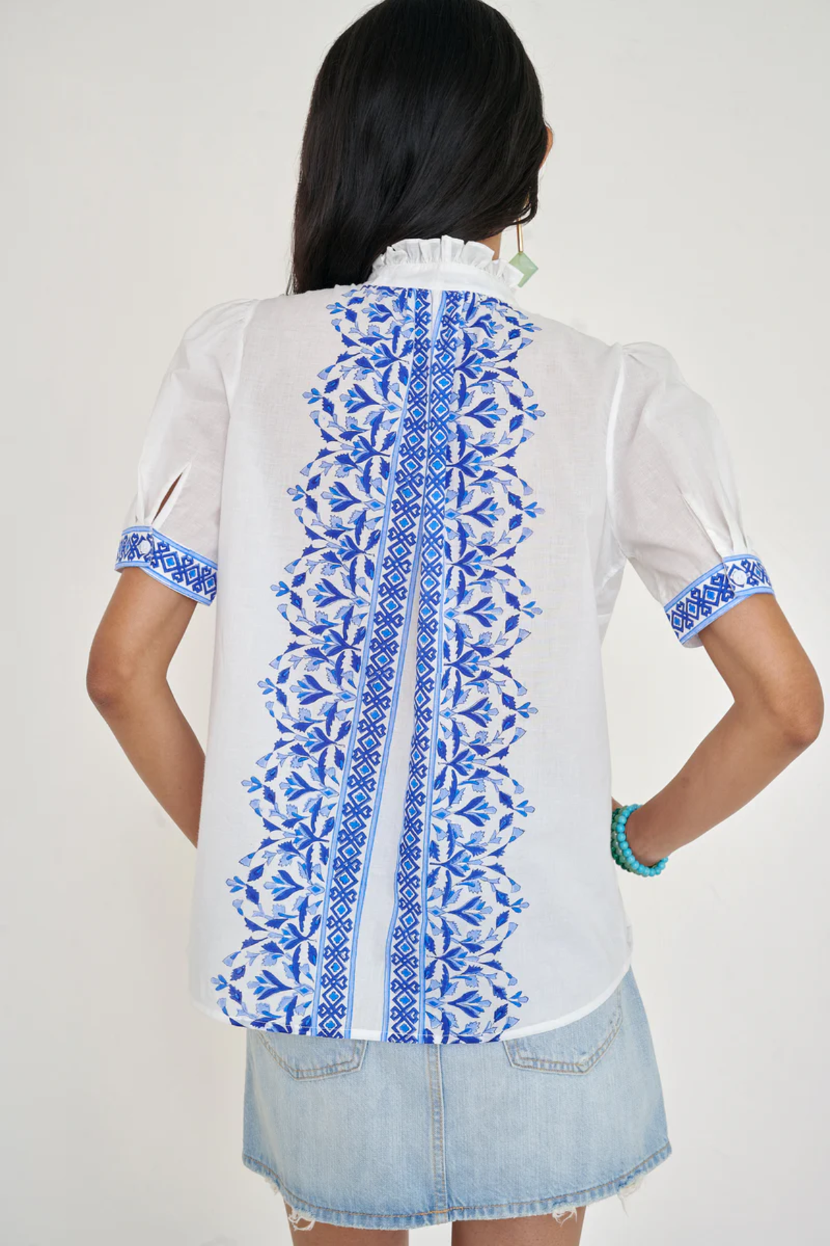 White top with blue printed detailing modeled on white background