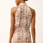 back of woman in halter style dress on white background 