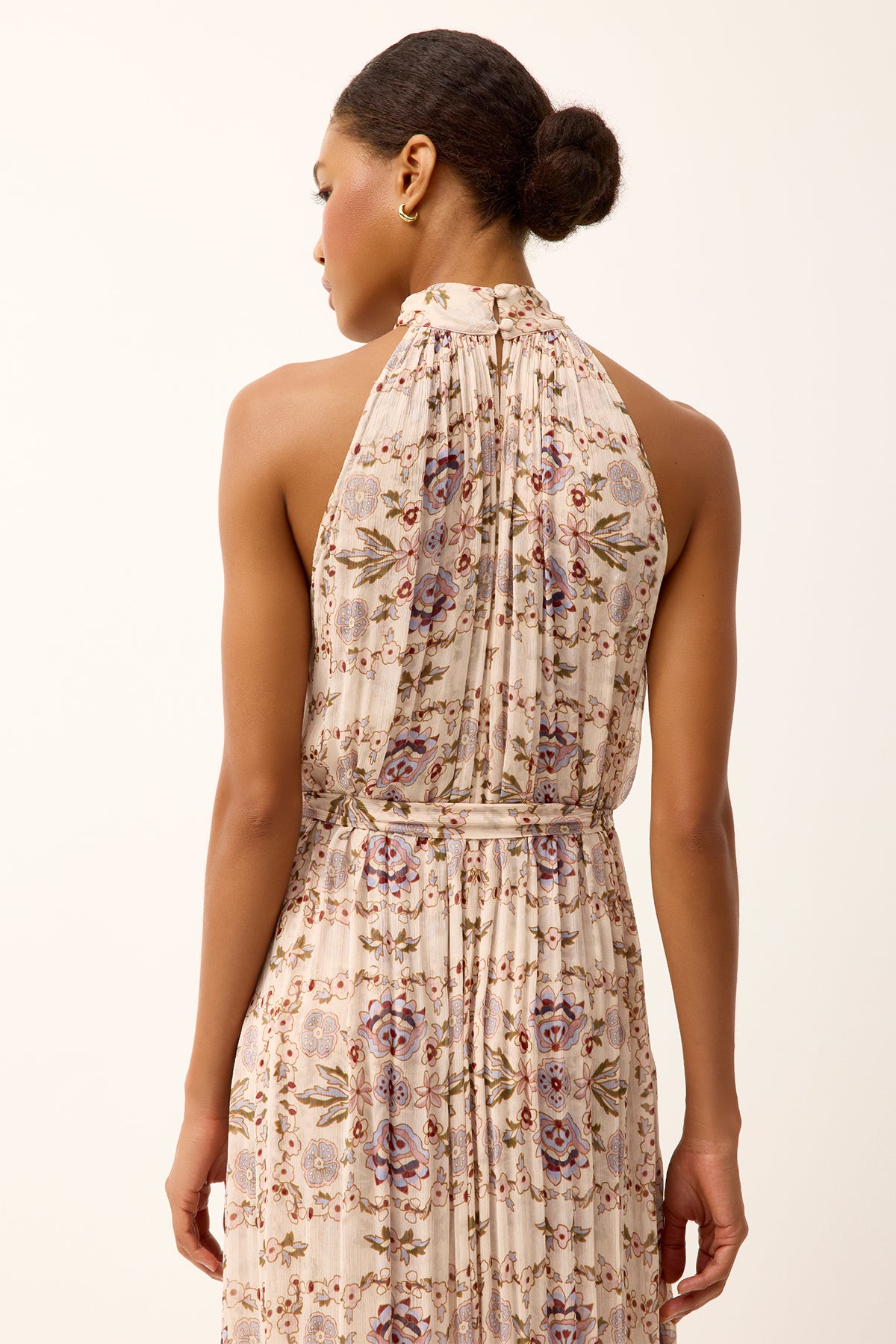 back of woman in halter style dress on white background 