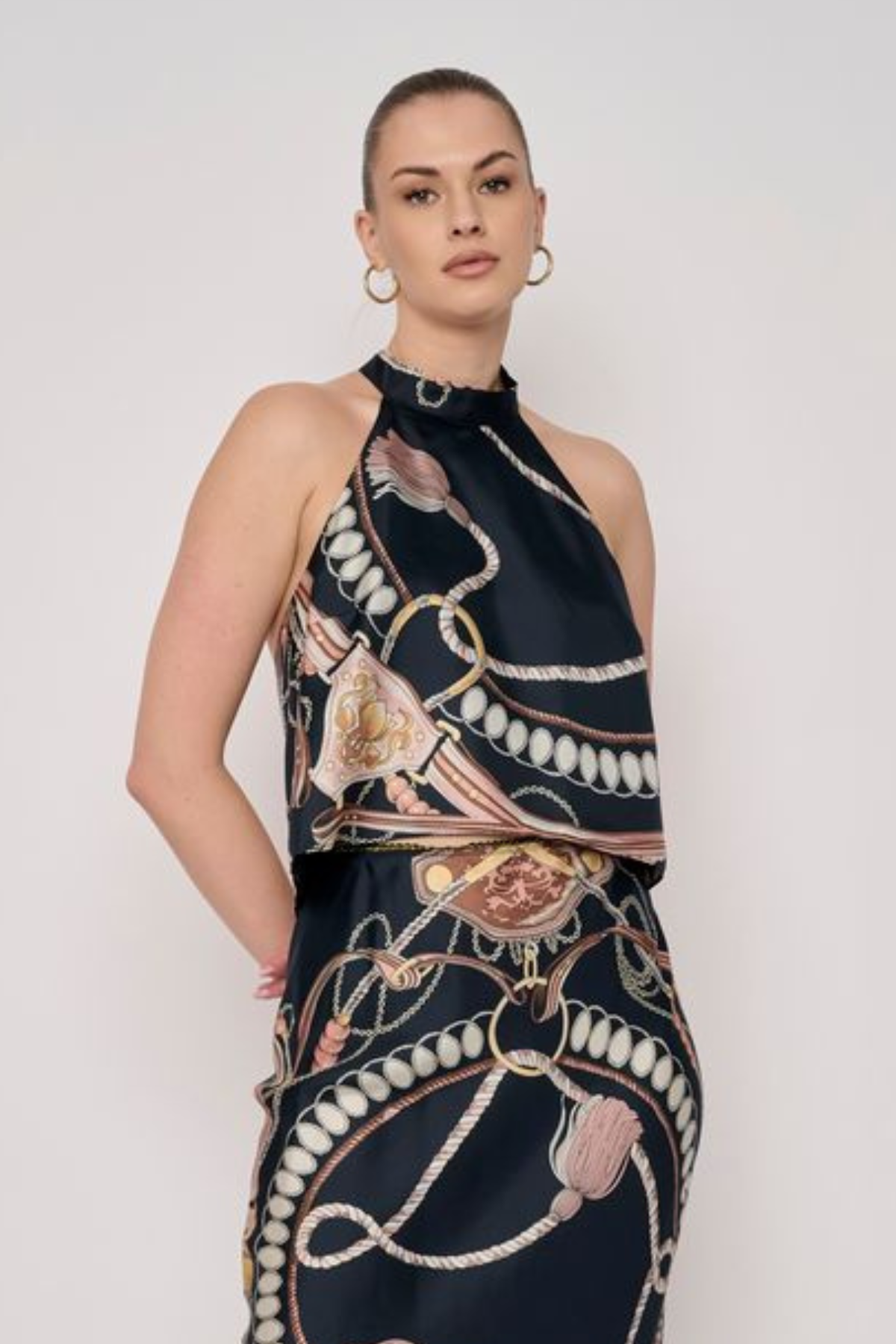 Model wearing a sleeveless printed halter top with a coordinating floral-inspired pattern and relaxed silhouette.