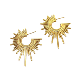 Gold sunburst earrings on a white background