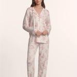 Woman wearing a floral pajama set on a white background