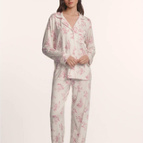 Woman wearing a floral pajama set on a white background