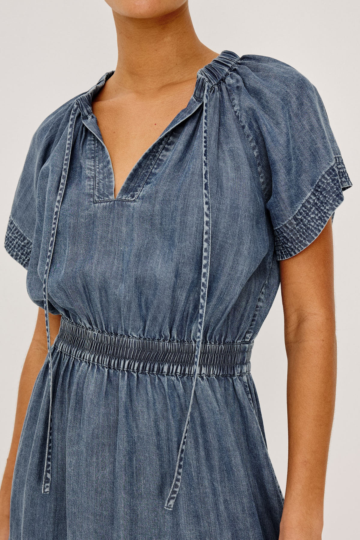 Denim dress with puff sleeves on a plain background