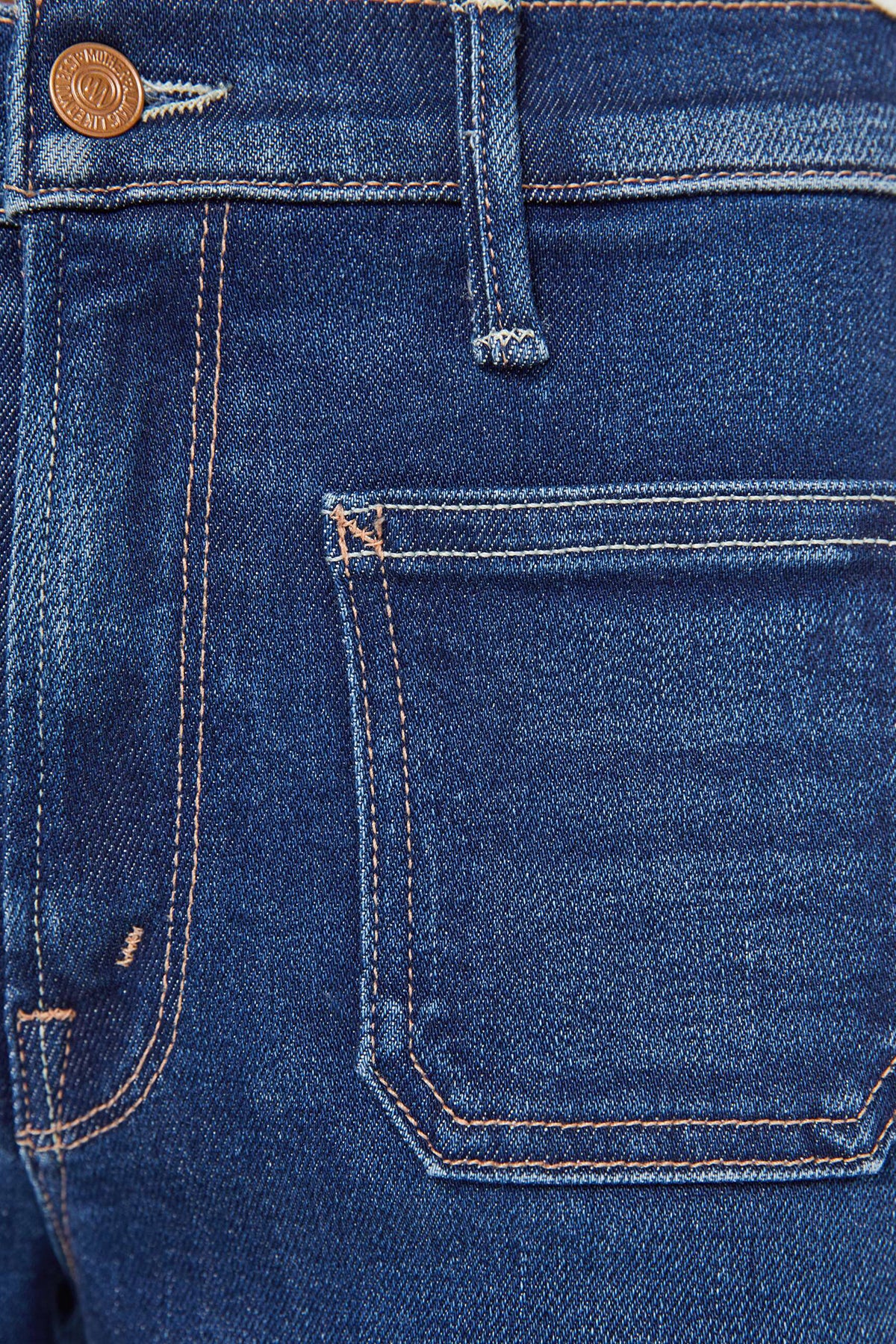 Close-up of blue denim jeans with a pocket and button detail.