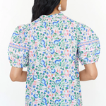 Woman wearing a floral patterned shirt on a white background