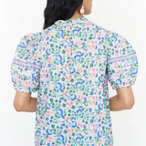 Woman wearing a floral patterned shirt on a white background