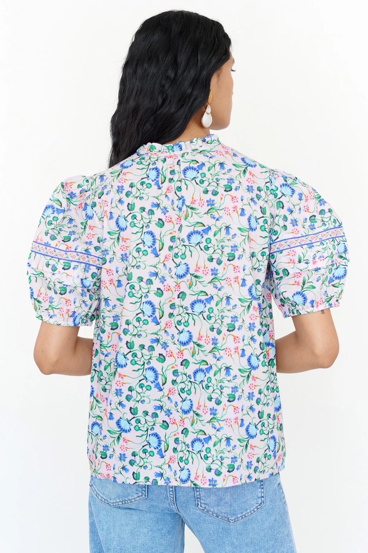 Woman wearing a floral patterned shirt on a white background