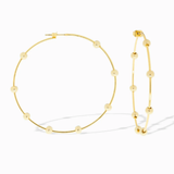 Gold hoop earrings with bead detailing on a white background