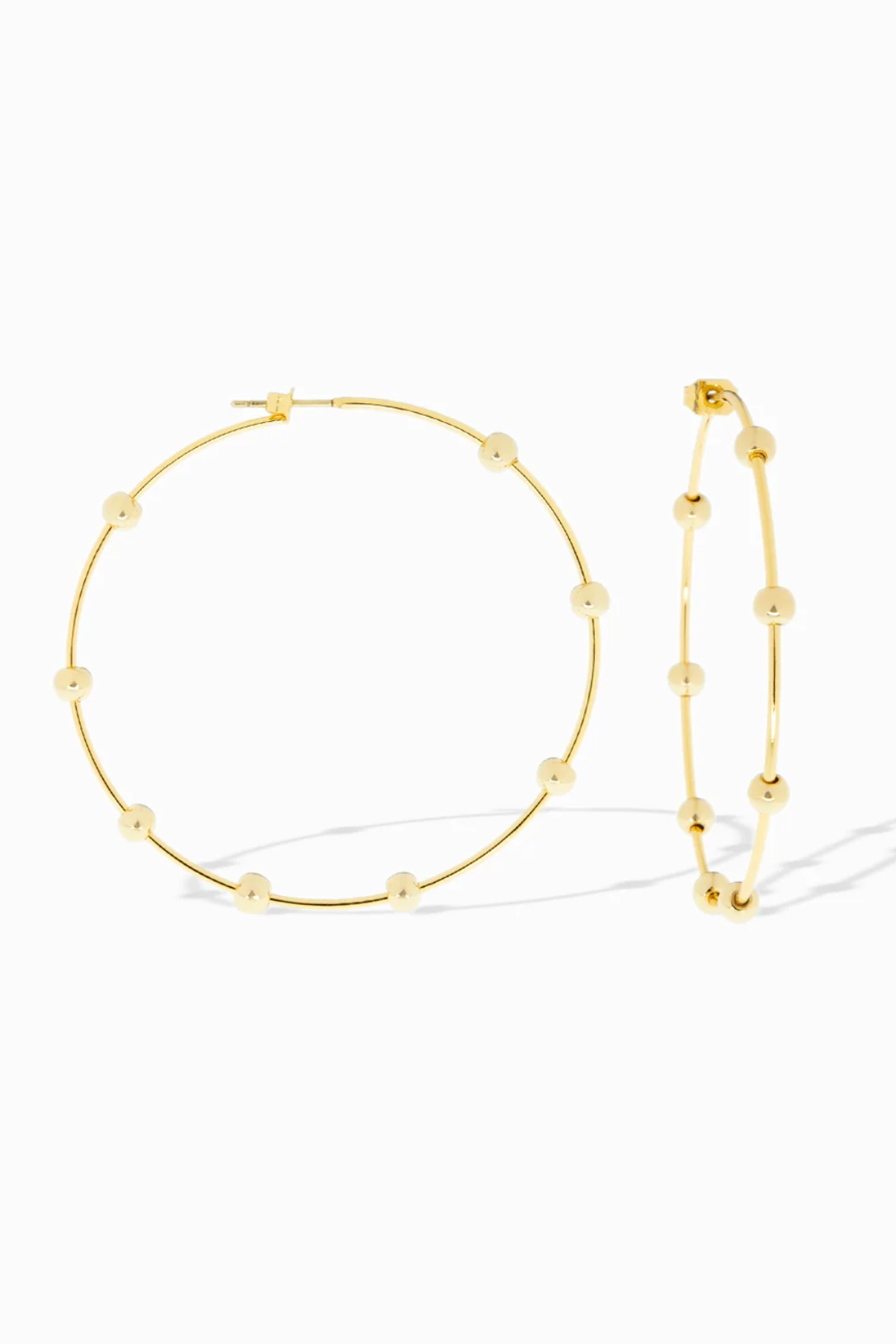 Gold hoop earrings with bead detailing on a white background