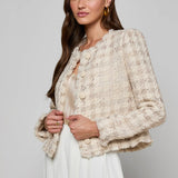 Collarless tailored jacket in a neutral tone, styled over a lightweight top