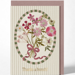 A floral greeting card with a striped cream background, an oval bouquet illustration in pink, green, and beige tones, and the text 'Thanks a bunch!' at the bottom, shown with a mauve envelope behind it on a light gray background.