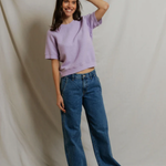 woman in short sleeve purple top on draped background 