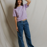 woman in short sleeve purple top on draped background 