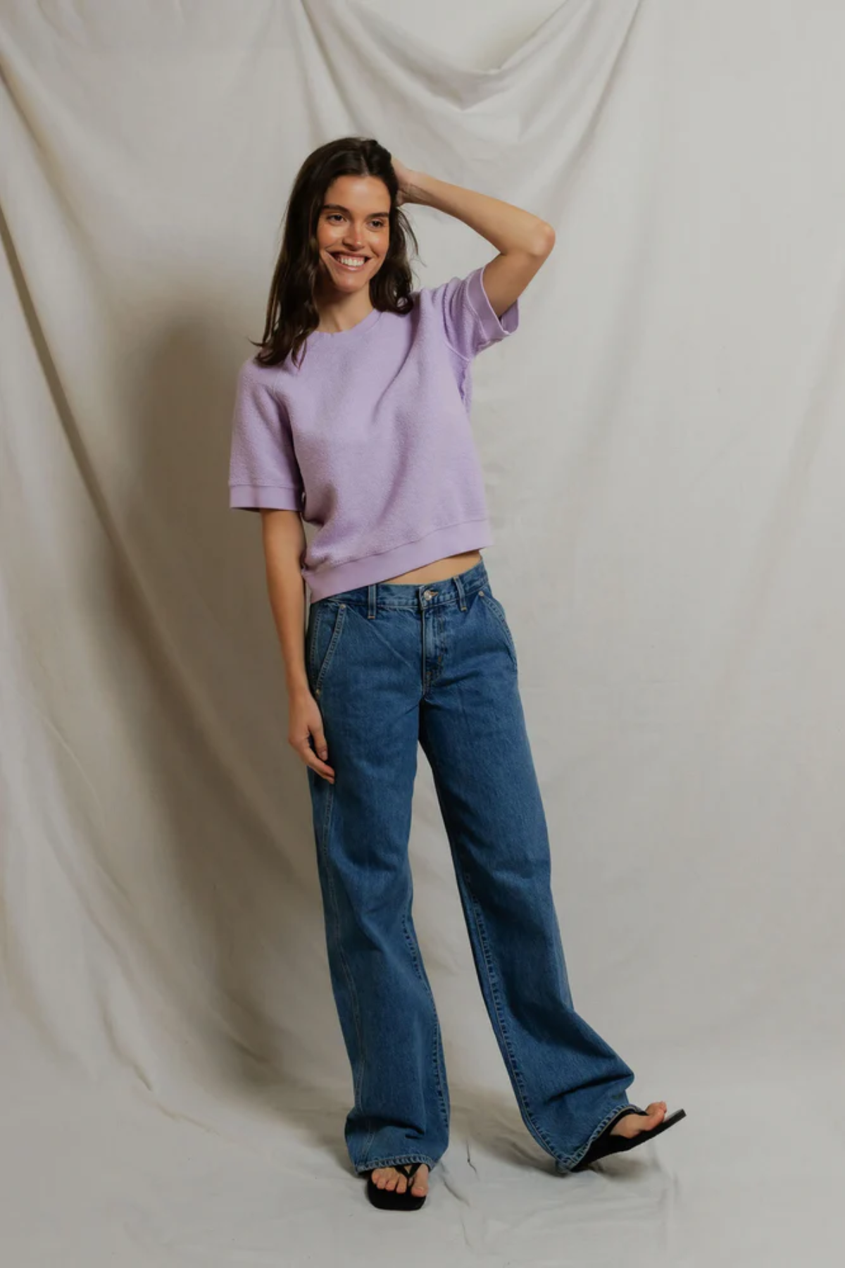 woman in short sleeve purple top on draped background 