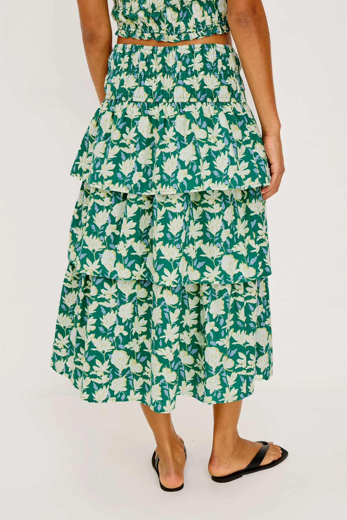 Woman wearing a green floral dress on a white background